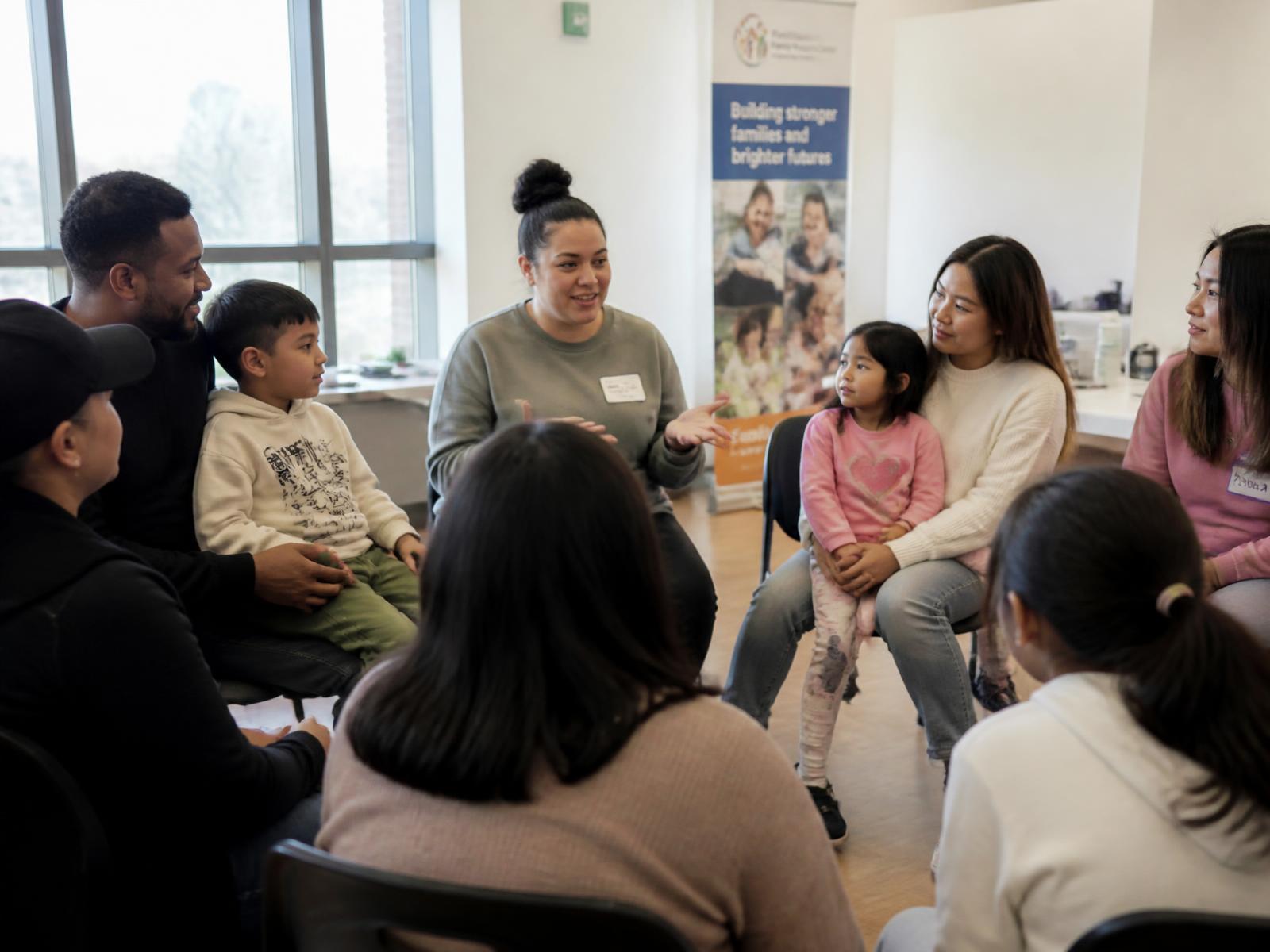 Parents and children in a community family workshop circle